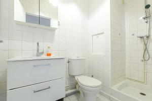 a white bathroom with a toilet and a sink at Le Petit Auber & son balcon, à 2 pas de Paris in Aubervilliers +20 photos
