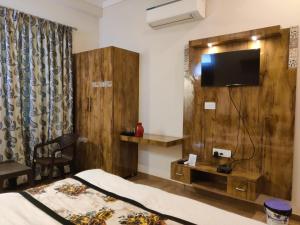 a room with a bed and a tv on a wall at The Boho Udaipur in Udaipur +16 photos