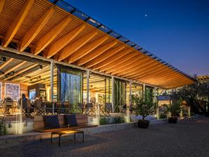 a building with a wooden pergola with benches and tables at Boutique Guesthouse - Marina Monfalcone in Monfalcone