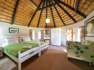 a bedroom with a large green bed in a room at Lake Naverone Holiday Cottages in Drakensberg Garden