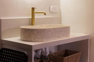 ein Waschbecken mit einem goldenen Wasserhahn auf der Theke in der Unterkunft Dousmani Old Town Studio in Korfu-Stadt