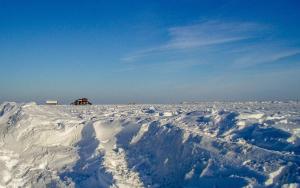 a snow covered field with a house in the background at Strandmatte in Böhl +3 photos