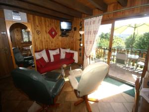 a living room with a couch and chairs and a balcony at Chalet in Hommert near Sarrebourg in Hommert