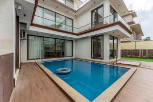 an image of a house with a swimming pool at StayVista at Villa Alora with Jacuzzi in Lonavala
