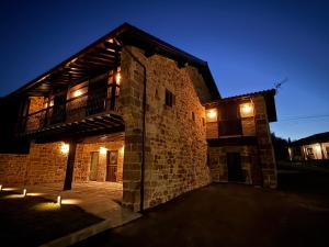a building with a balcony on the side of it at night at Zurita Rural Suites in Zurita