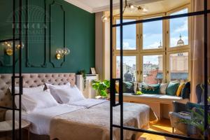 een groene slaapkamer met een bed en een raam bij Feniks Fragola Apartments in Krakau