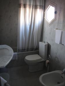 a bathroom with a toilet, sink and tub at Hotel Il Falchetto in Pontedera