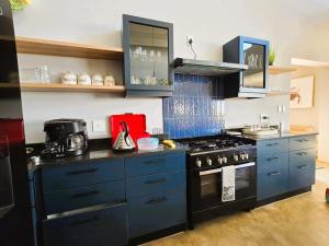 a kitchen with blue cabinets and a stove top oven at House 427 Windspur Estate in Nottingham Road