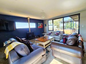 a living room with two couches and a table at House 427 Windspur Estate in Nottingham Road