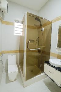 une salle de bain avec une douche, des toilettes et un lavabo dans l'établissement Ginik Suite And Apartments, à Lagos