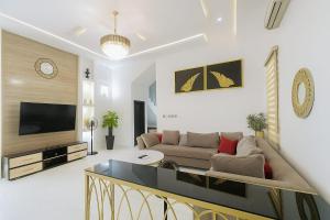 a living room with a couch and a tv at Ginik Suite And Apartments in Lagos