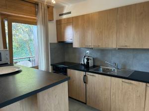 a kitchen with wooden cabinets and black counter tops at Magrappe M 440 - SKI LIFT apartment 7 pers in Veysonnaz