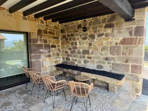 a patio with chairs and a stone wall at Zurita Rural Suites in Zurita