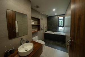 een badkamer met een wastafel, een toilet en een bad bij Navilla Huế Homestay in Thôn An Hòa +17 foto's