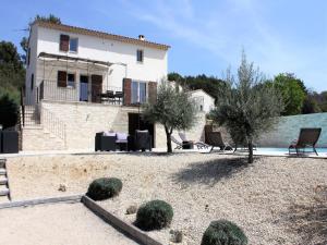 a house with a yard with chairs and trees at Villa in Lubéron with Saltwater Pool in Apt