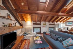 蓬圣马丁La Mansarda del Viaggiatore的客厅里有一张蓝色沙发和一台电视