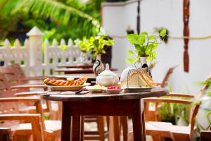 L&D Lodge في هيكادوا: طاولة خشبية عليها صحون فاكهة