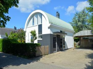 a white chapel with an arched window and a green roof at Holiday Home in Noordwijk near the Beach in Noordwijk
