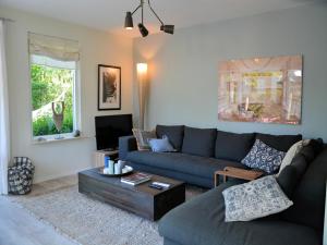 a living room with a blue couch and a coffee table at Holiday Home in Noordwijk near the Beach in Noordwijk +32 photos