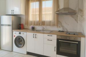 a kitchen with a refrigerator and a washing machine at KELLY APARTMENTS in Ipsos