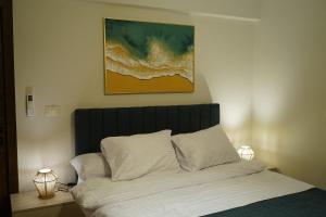 a bed with white pillows and a painting above it at kornfil guest house in New cairo