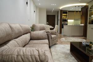 a living room with a couch and chairs and a kitchen at kornfil guest house in New cairo