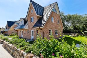 een groot bakstenen huis met een metalen dak bij Haus Dock 10 in Westerland