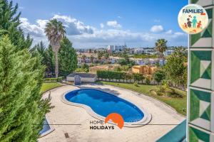 a villa with a swimming pool and a palm tree at #201 Families Only - Quinta da Flor in Vale de Pedras