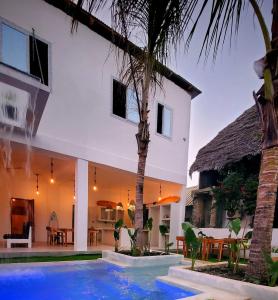 a villa with a swimming pool in front of a house at Beautiful Luxury 8 sleeper Double Storey Villa & Private Pool Paje Beach Zanzibar in Paje