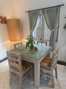 - une table à manger avec 2 chaises et une corbeille de fruits dans l'établissement MM Villa Ungasan, à Uluwatu