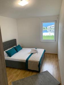 a bedroom with a bed with blue pillows and a window at منتجع سراييفو - Sarajevo Resort in Sarajevo