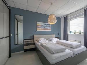 a bedroom with two beds and a mirror at Beachside home with balcony in Julianadorp