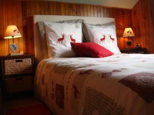 a bedroom with a bed with red pillows with deer on it at Chalet in Hommert near Sarrebourg in Hommert