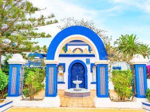 ein blaues Haus mit einem Brunnen davor in der Unterkunft Holiday home in Roquetas de Mar by the sea in Roquetas de Mar