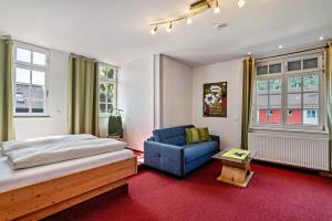 a bedroom with a bed and a blue chair at Landhaus Christophorus in Forbach