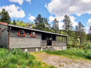 a cabin in the woods with red windows at 6 person holiday home in ÅSERAL-By Traum in Hamkoll