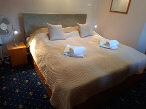 a bedroom with a large bed with towels on it at Vila Viktória in Rajecké Teplice