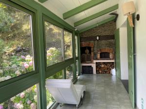 a screened in porch with windows and a fireplace at Villa fleurie - maison familiale, véranda et jardin in Tende