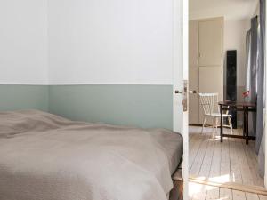 a bedroom with a bed and a table with a chair at 4 star holiday home in Ulfborg in Ulfborg