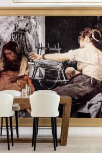 a painting on the wall in a room with chairs at Palacio de los Duques Gran Meliá - The Leading Hotels of the World in Madrid