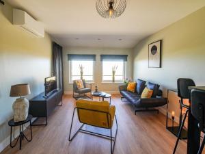 Una sala de estar con un sofá y un televisor. en Apartment in Katwijk near the Beach, en Katwijk