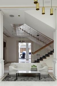 a living room with a staircase and a table at Palacio de los Duques Gran Meliá - The Leading Hotels of the World in Madrid