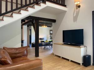 a living room with a couch and a flat screen tv at Villa fleurie - maison familiale, véranda et jardin in Tende