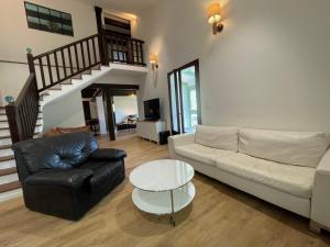 a living room with a couch and a table at Villa fleurie - maison familiale, véranda et jardin in Tende
