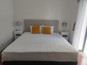 丰沙尔Alexia Room的卧室里有一张白色的大床，床边还有两盏灯