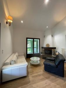 a living room with a couch and a table at Villa fleurie - maison familiale, véranda et jardin in Tende