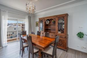 Un comedor con mesa y sillas de madera. en Stunning sea view apartment in Burgau #1897, en Burgau