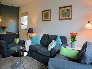 Una sala de estar con dos sofás azules y una mesa. en Holiday Home Noordwijk near the Beach, en Noordwijkerhout