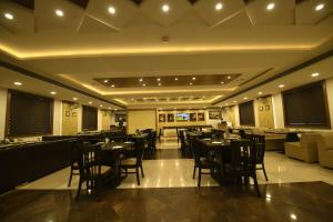 a restaurant with tables and chairs and a bar at Hotel LA PEARL, Bhopal in Bhopal +39 photos