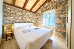 a bedroom with a large bed in a stone wall at Kamena vila in Kornić